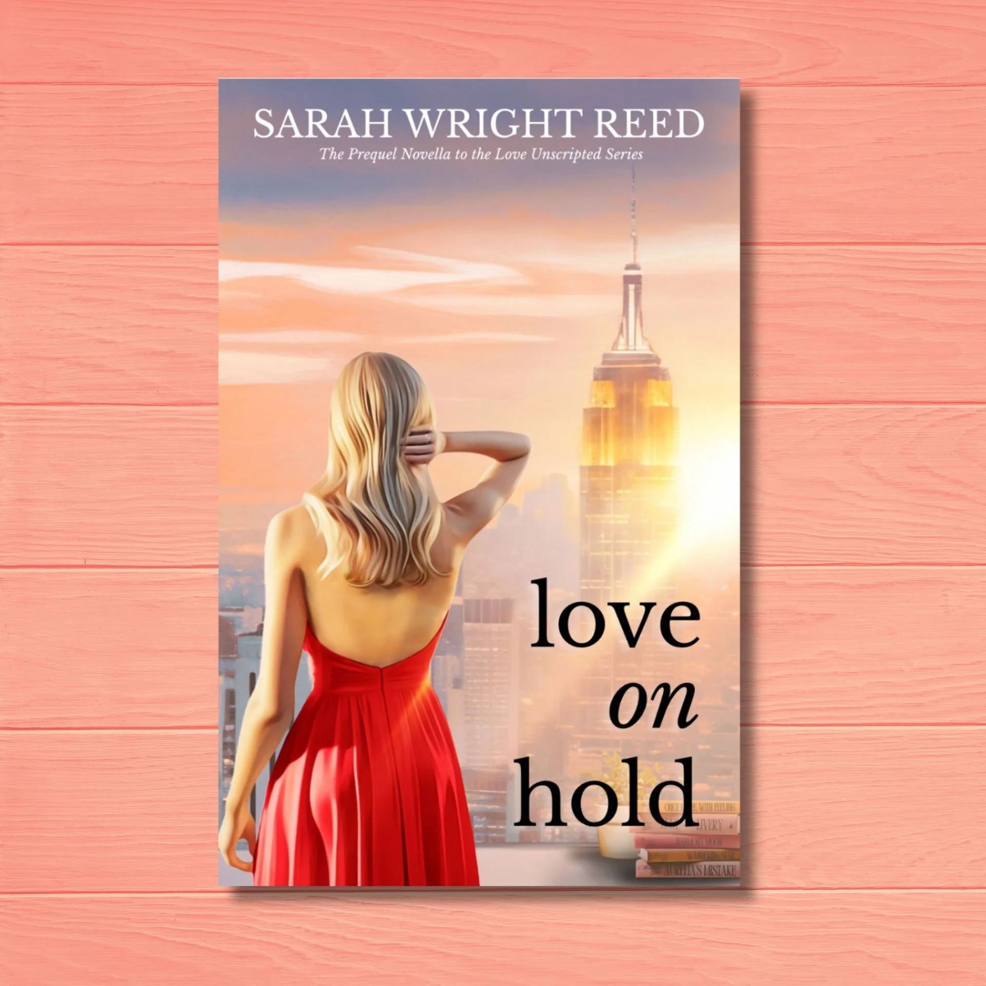 Book cover for 'Love on Hold' by Sarah Wright Reed with a woman in a red dress looking at a city skyline at sunset.