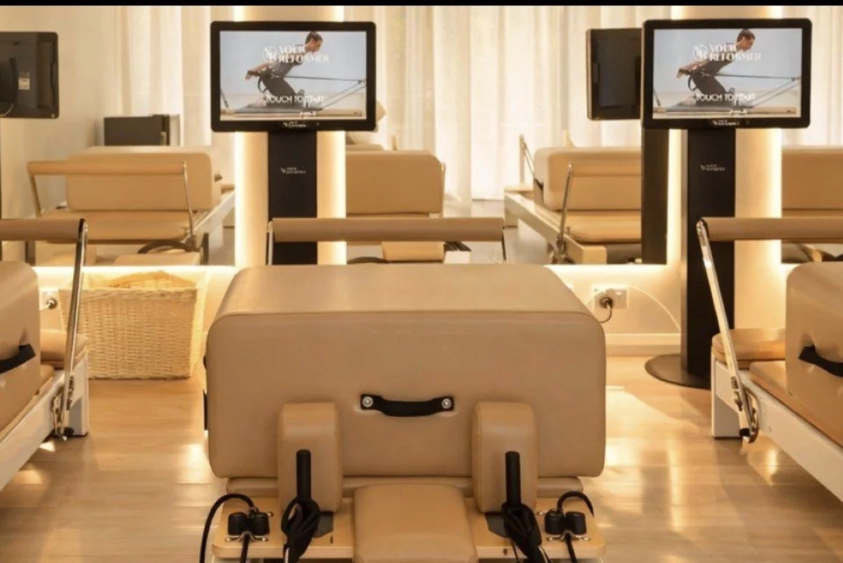 Pilates reformer with a self-guided kiosk displaying a Pilates move.