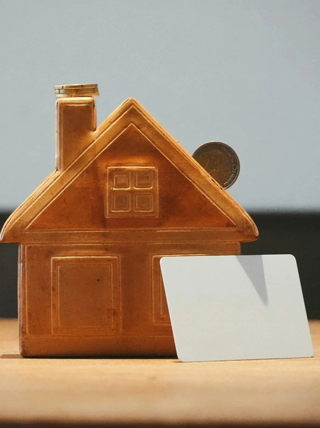 Image of model home with a penny and a blank card