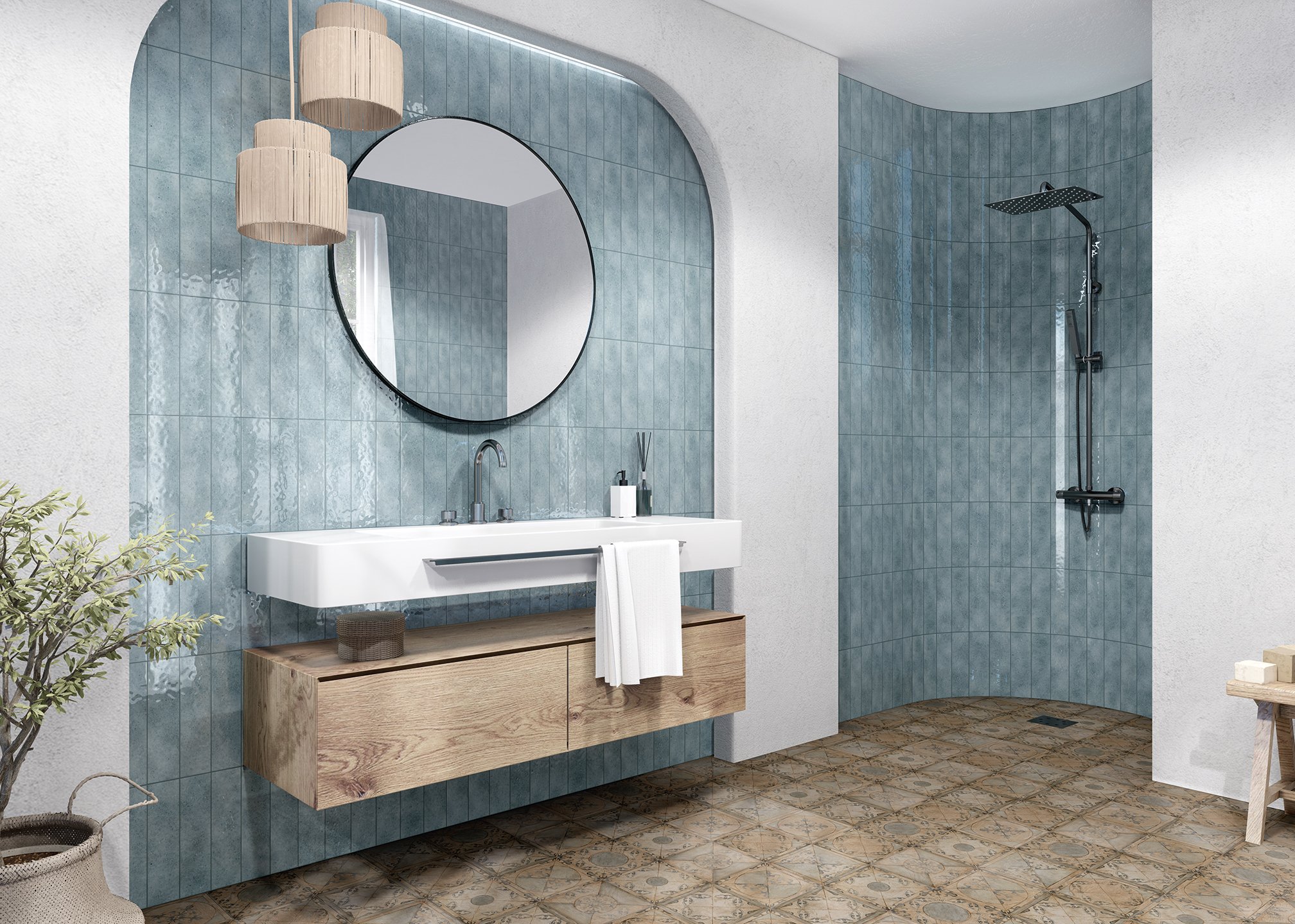 Salle de bain moderne avec un miroir rond, un lavabo en bois, un plafond en béton, carrelage bleu sur les murs, douche à l'italienne avec une pomme de douche noire, plante verte à gauche, panier en osier sous le lavabo, sol en carreaux décoratifs.