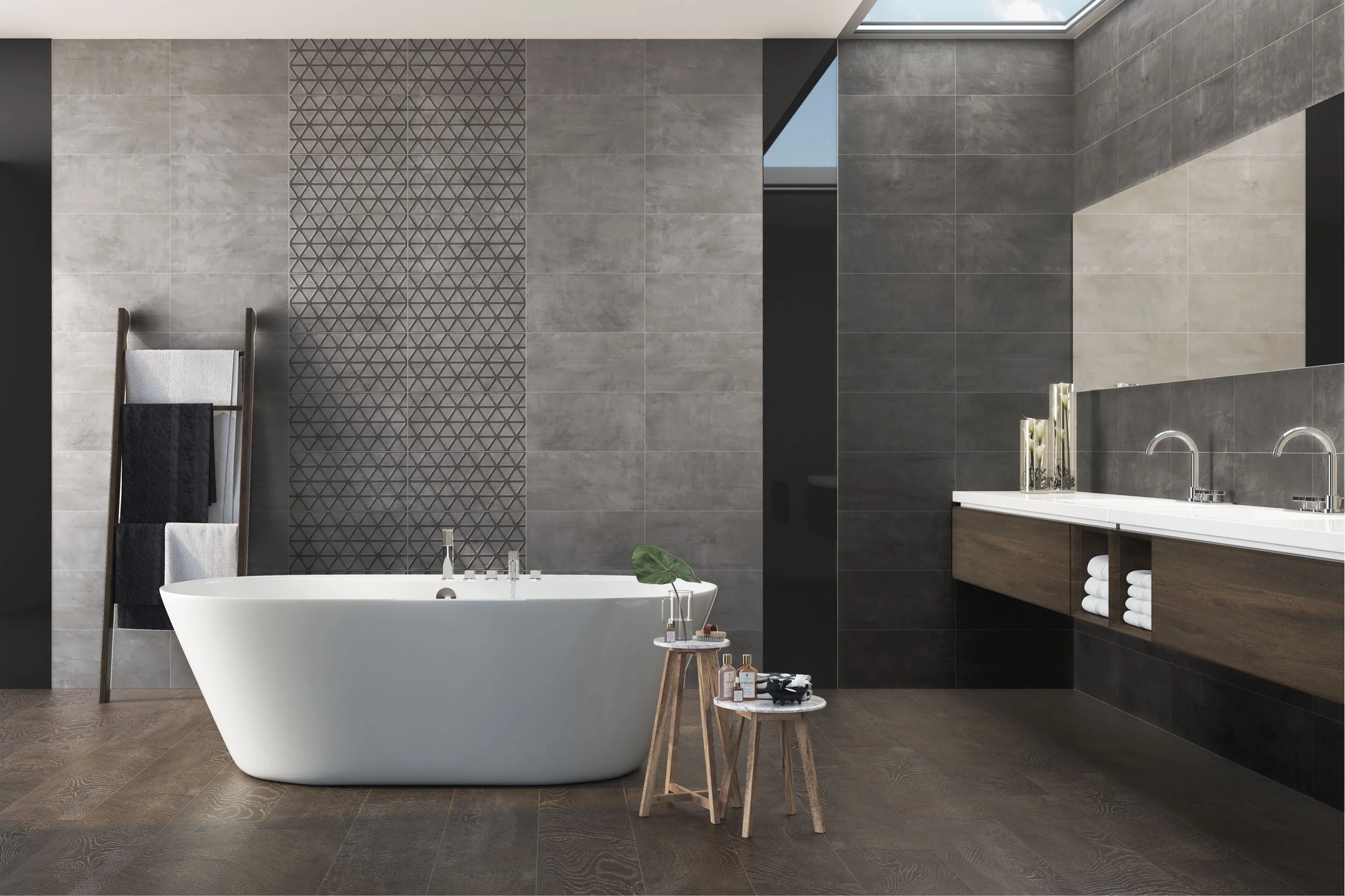 Salle de bain moderne avec une baignoire, un lavabo en bois, des murs en carreaux gris, un miroir, des accessoires de bain, et des serviettes blanches.