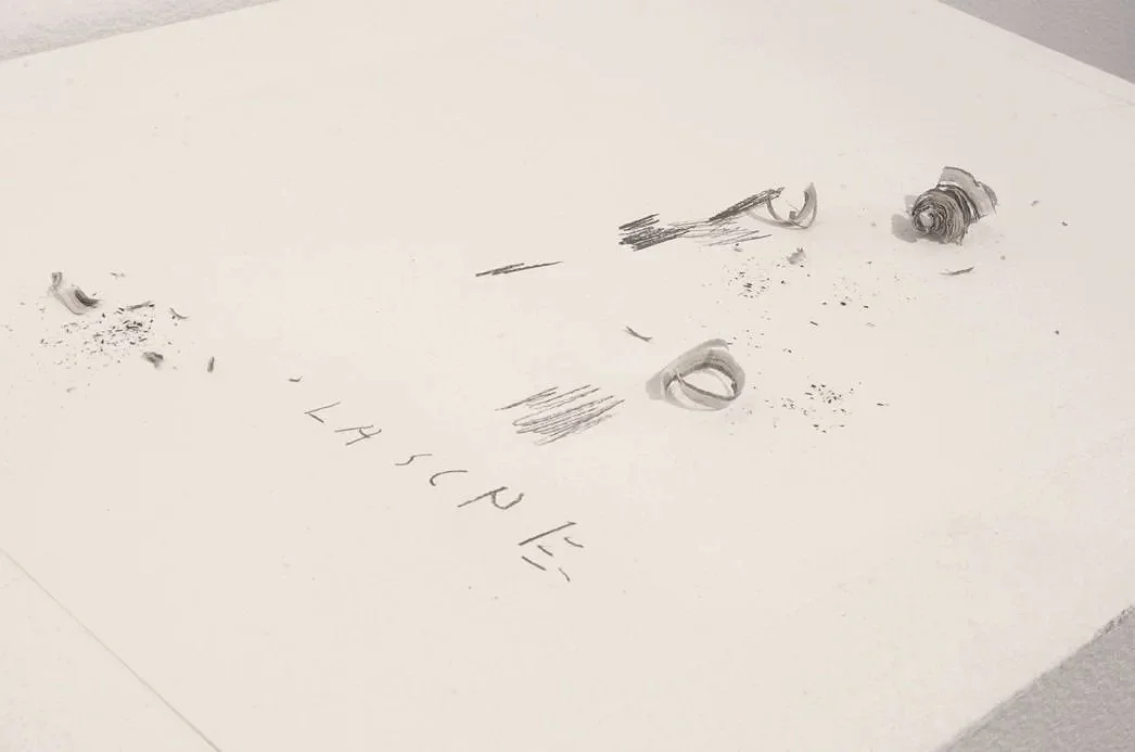 Messy paper with scribbles, small objects, and the words "LHS CUBE" written on it.