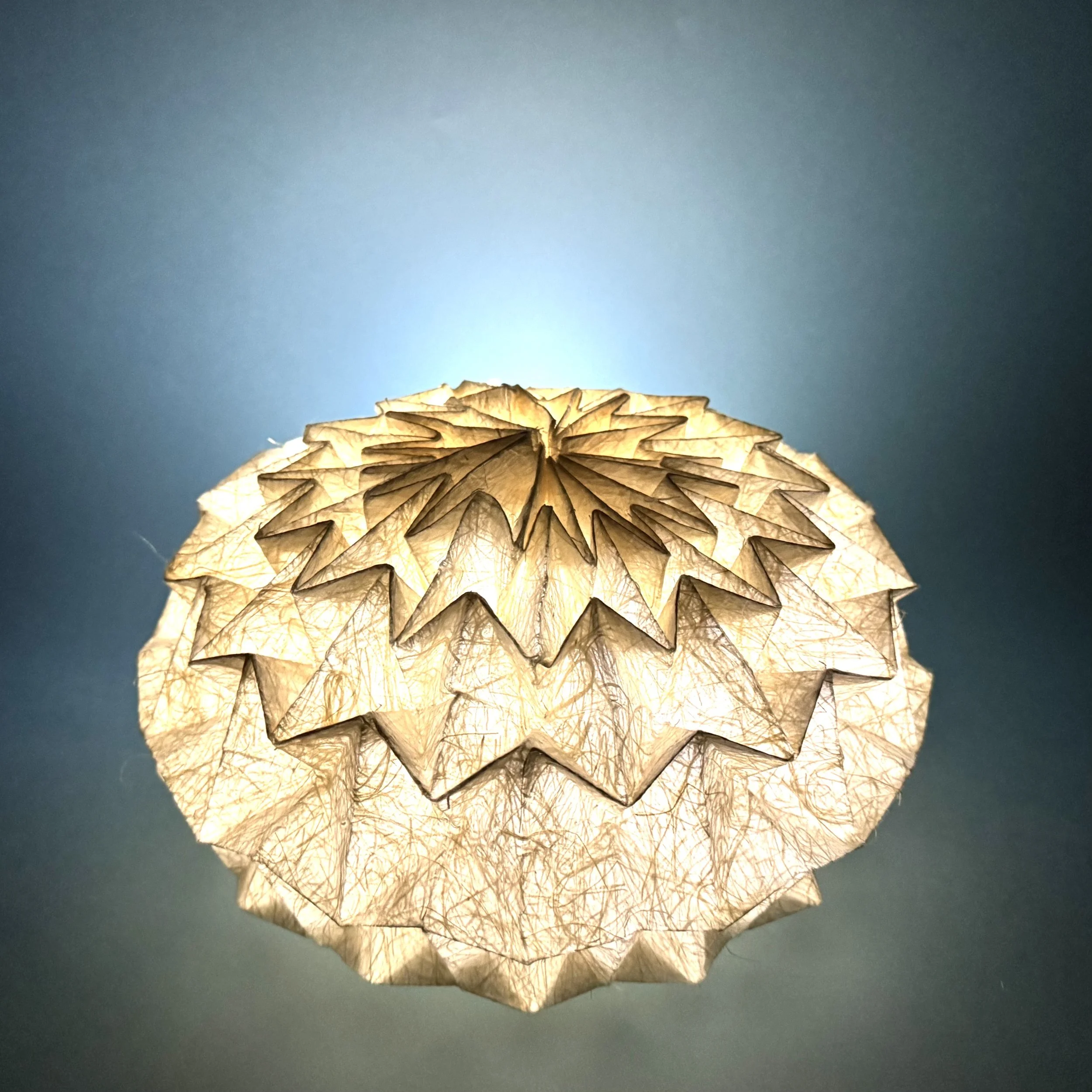 A Magic Ball fold — but made with Washi embedded with hemp fiber. When I folded it, the fibers pricked like thorns. I made gloves to protect my hands