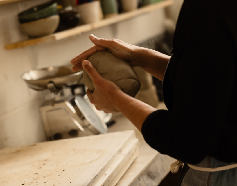 Une personne pétrit de la pâte à la main dans une cuisine.