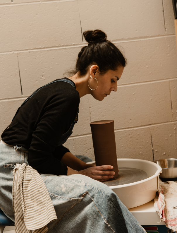 Une femme en train de faire de la poterie sur un tour.