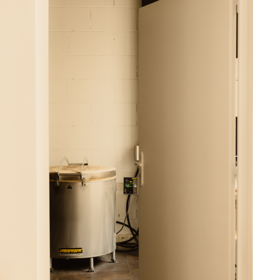 Une machine en acier inoxydable dans une pièce, probablement un congélateur ou une cuve de cuisine, avec un dispositif électrique et des câbles à côté.