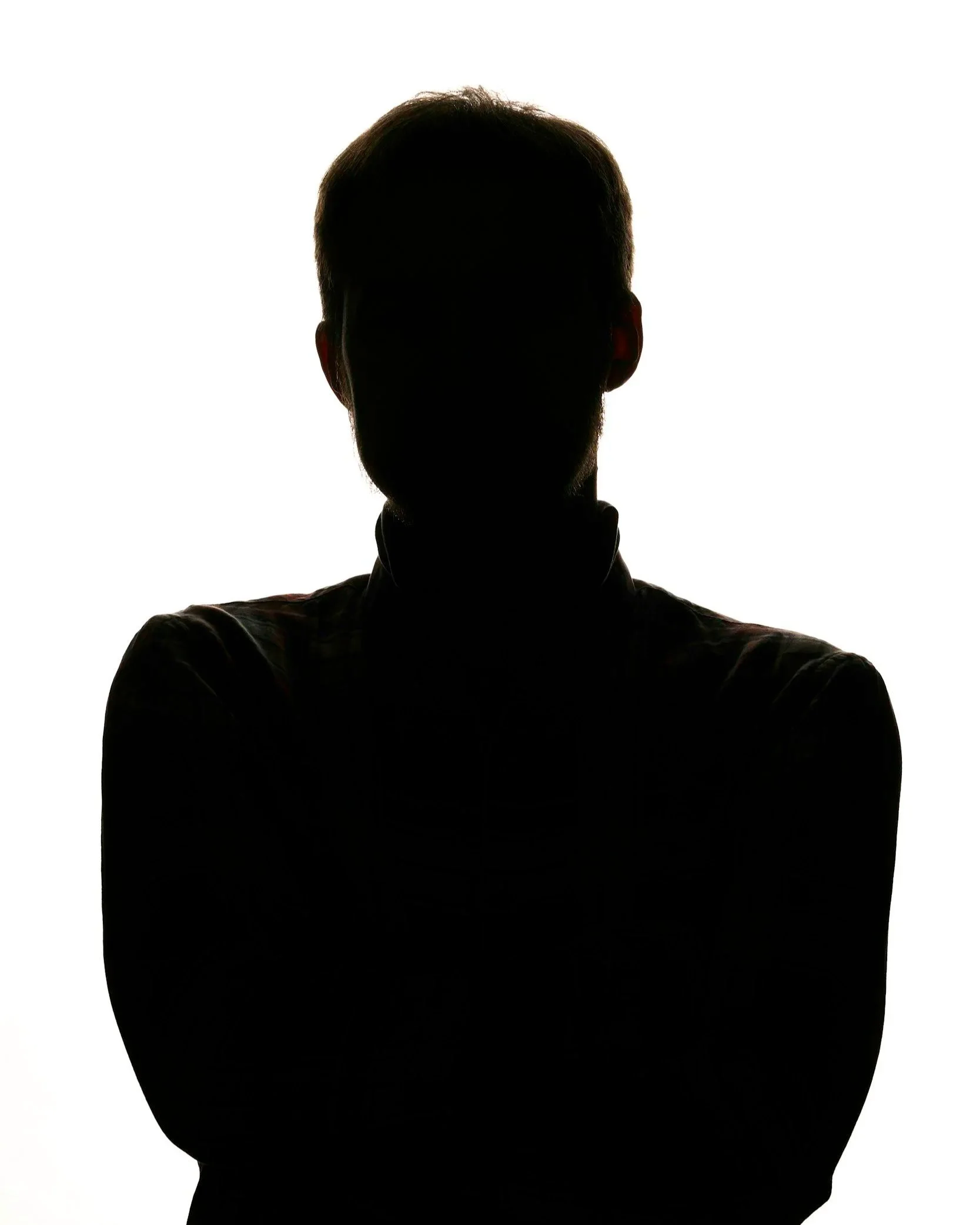 Silhouette of a man with crossed arms against a white background, no facial details visible.