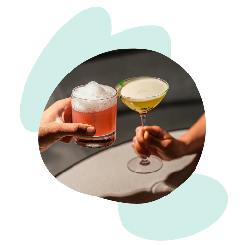 deux mains qui trinquent avec des cocktails