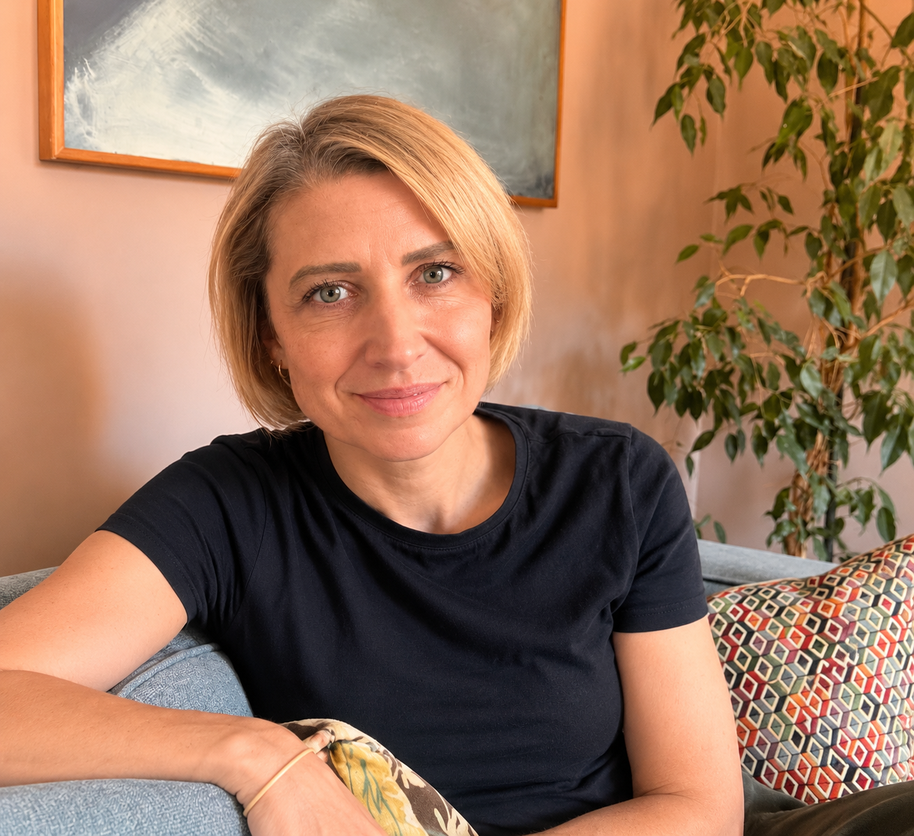 Joy Scott, founder of We Make Content Happen, sitting on a sofa.