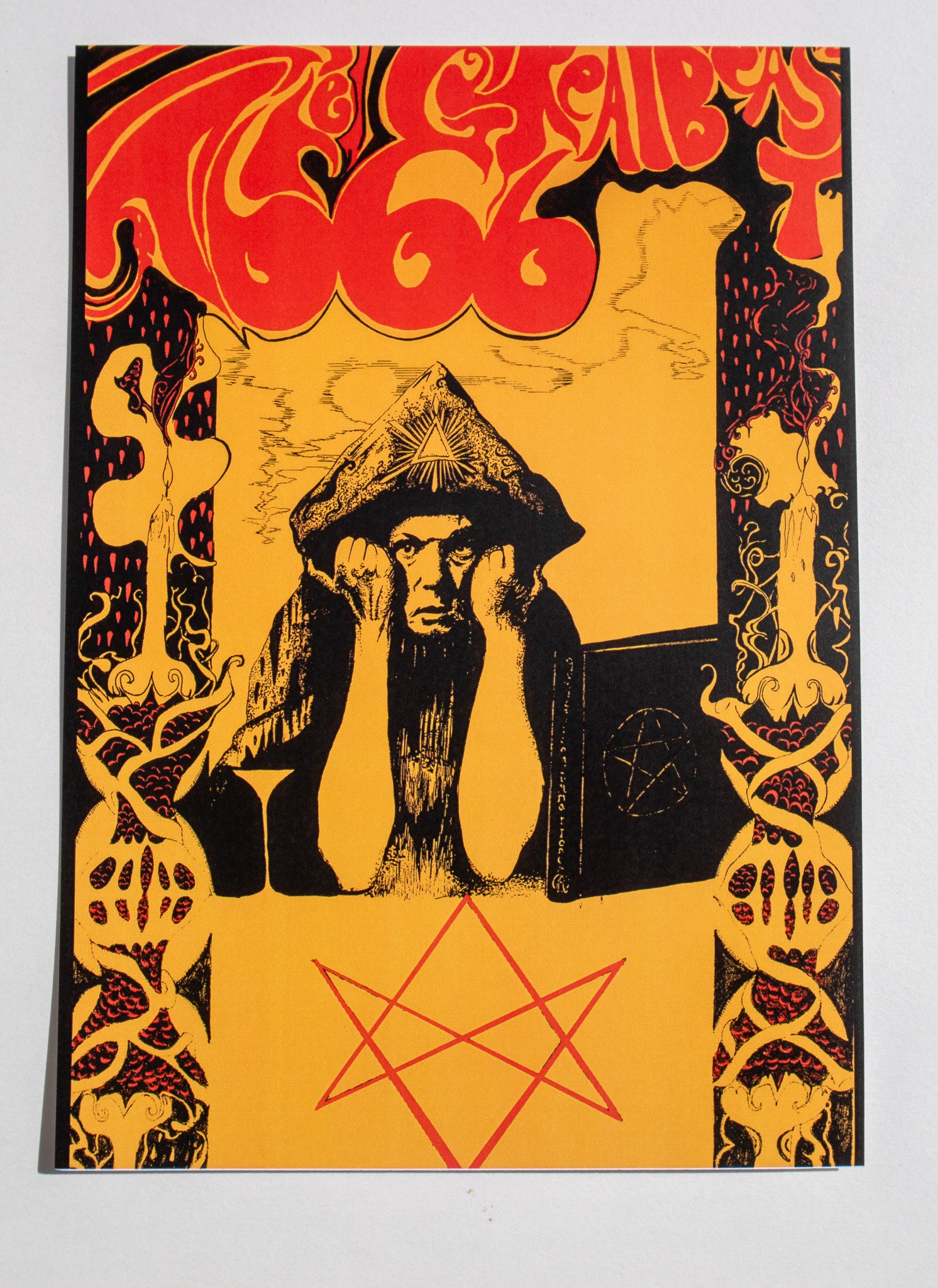 A print of a black and yellow psychedelic portrait of Aleister Crowley featuring red text reading 'The Great Beast 666' in a gothic pen and ink style.