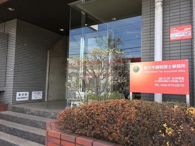 税理士事務所の看板とガラス張りの入り口の外観