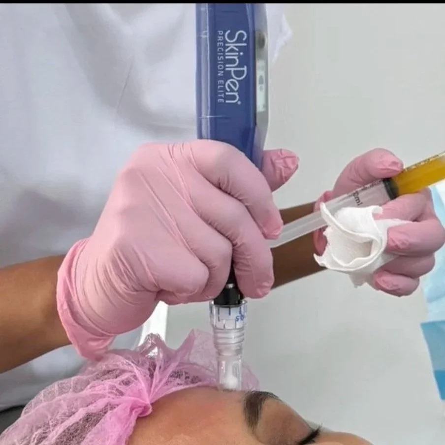 A nurse wearing pink gloves administering a facial treatment with a syringe and a tube of SkinPen Precision Elite to a patient lying down with a pink cap on her head.