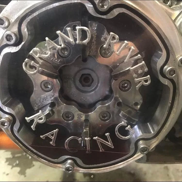 Close-up of a metal engine component with letters spelling 'CANDY RACING' attached to parts of the machinery.