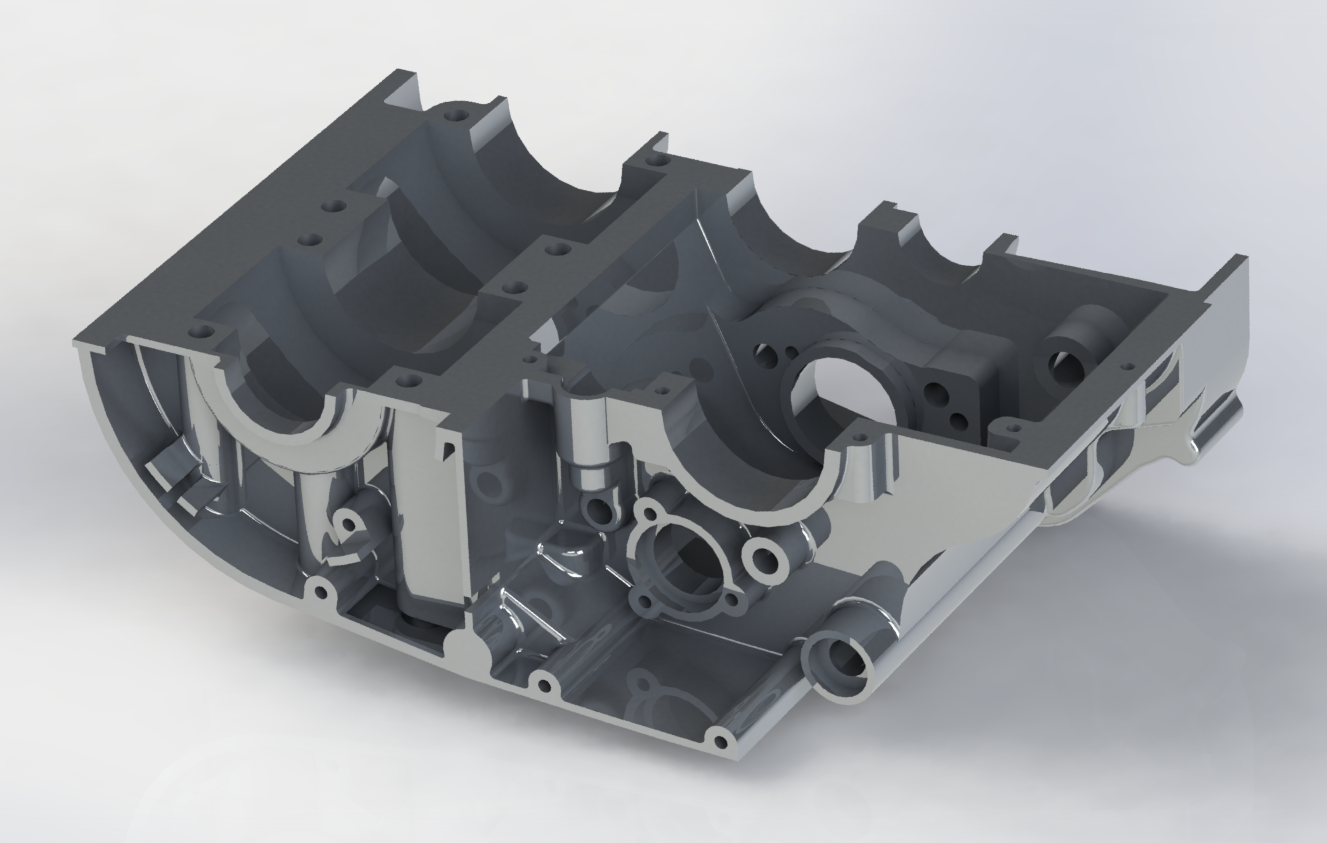 A metallic engine component housing with intricate internal chambers and mounting points.