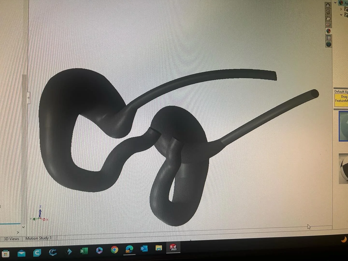 3D model of intertwined black metal pipes with smooth curves displayed on a computer screen.