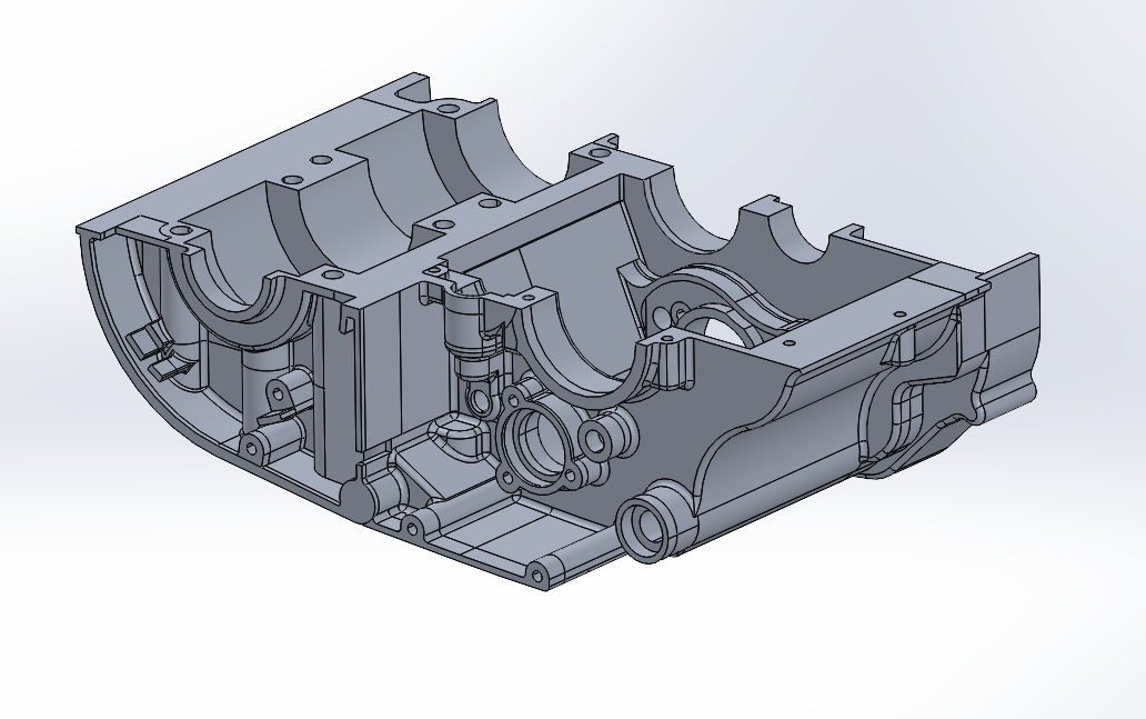A 3D CAD model of a mechanical engine component, showing internal chambers and mounting points.
