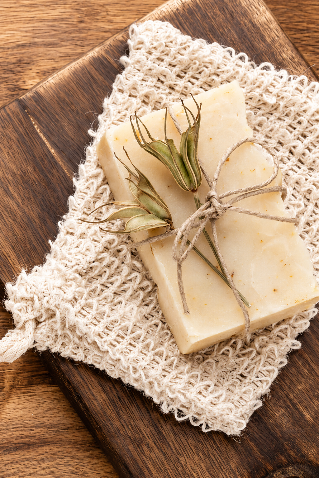 Handcrafted tallow me softly soap decorated with sprigs of dried botanicals, tied with twine, on a wooden board in an australian forest . Yanchep National Park
