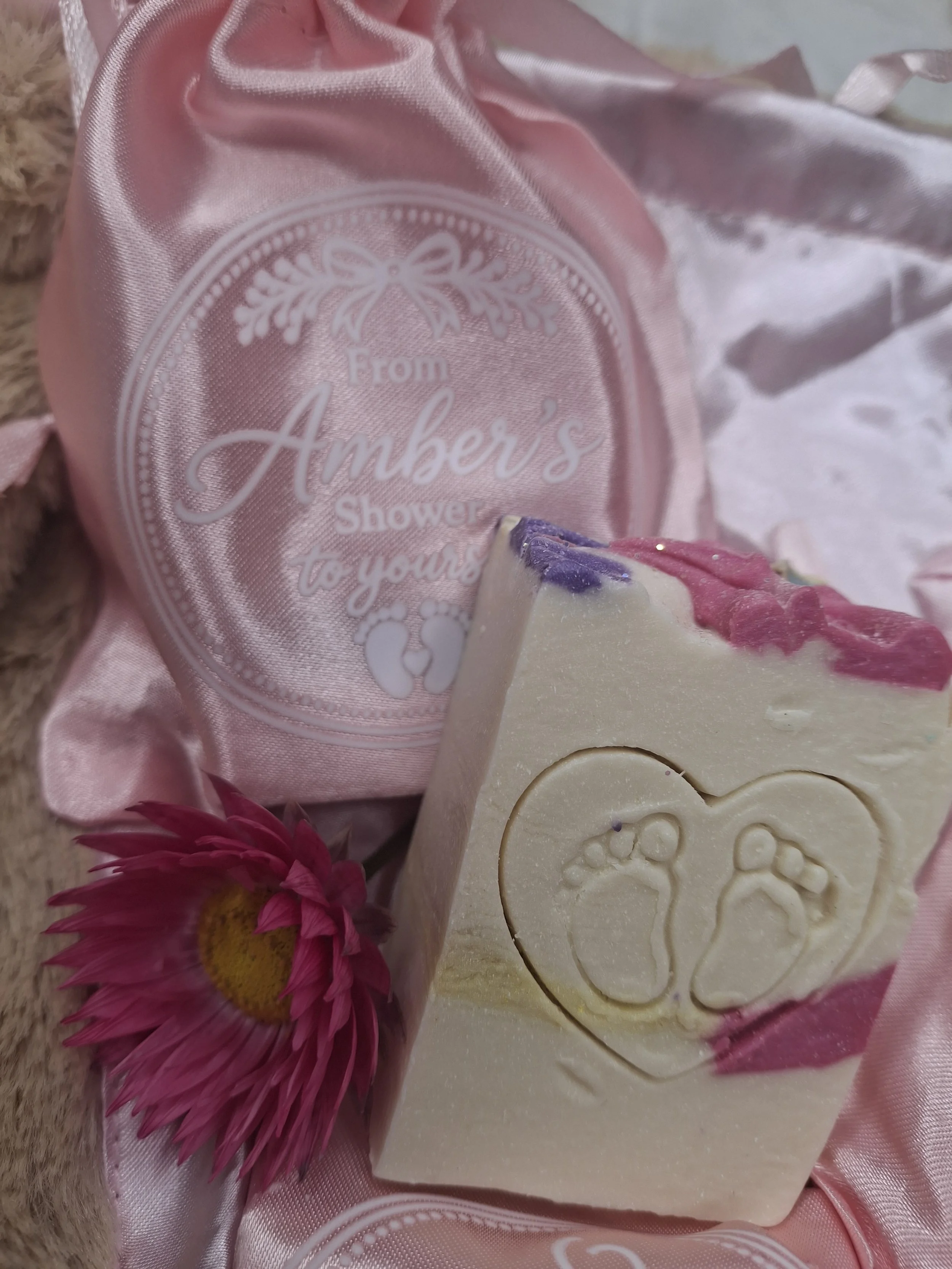 Pink, purple and lemon handmade baby shower soap favours featuring baby footprints inside a heart.
