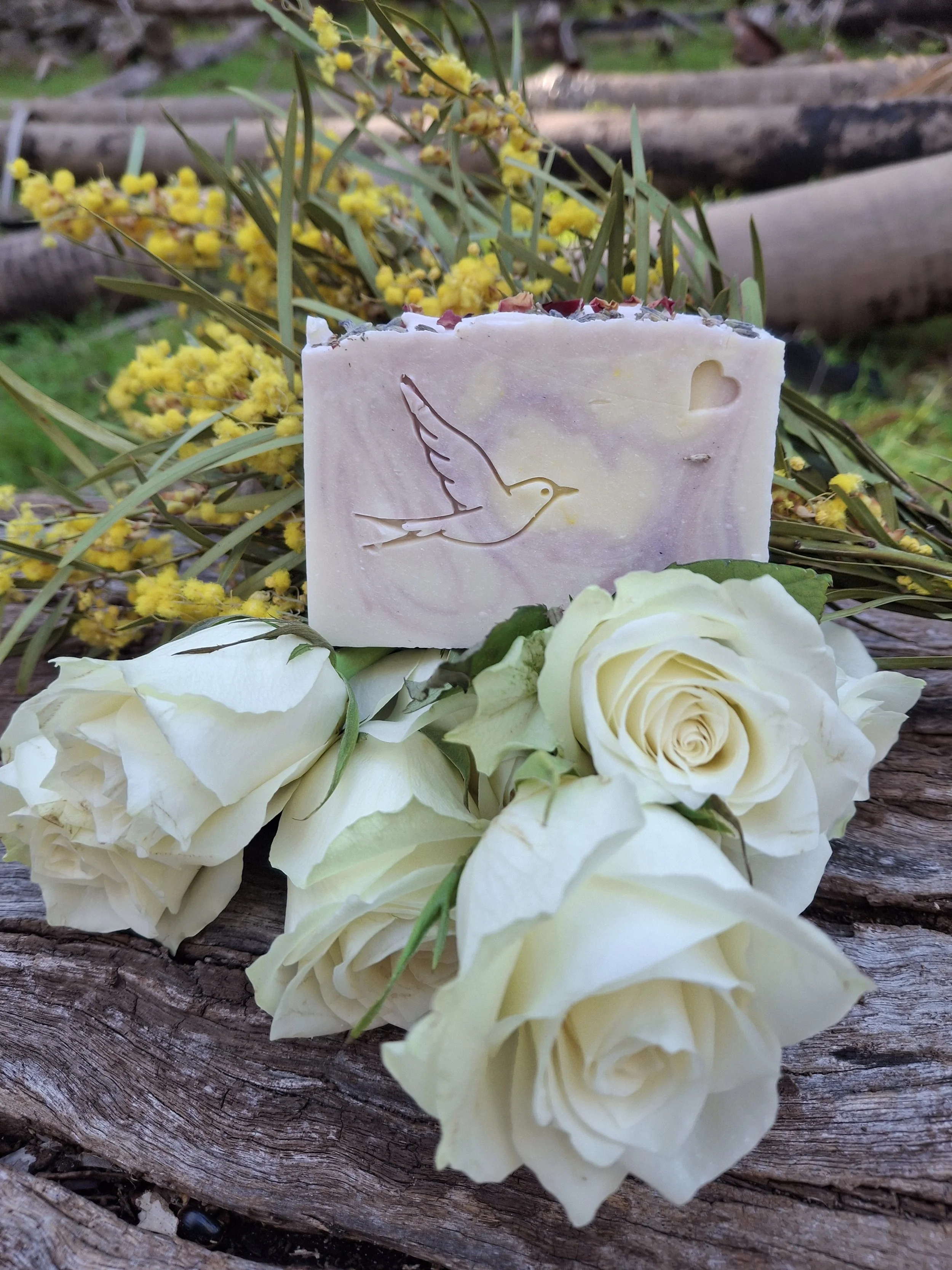 handcrafted soap with a dove design by tallow me softly, photographed with roses & botanical styling