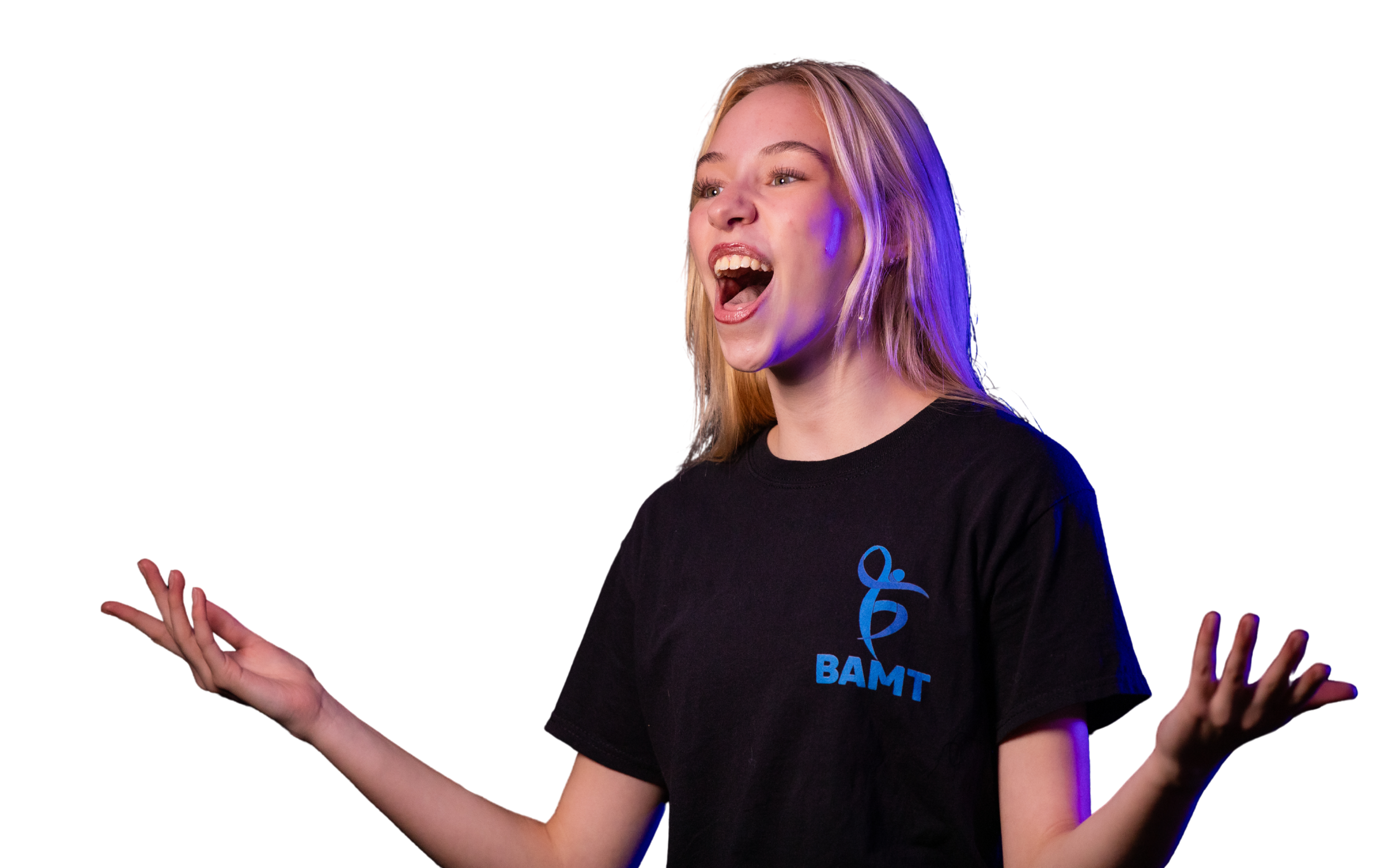 A young female BAMT student with blonde hair and light skin, wearing a black t-shirt with blue text, singing with her hands raised and fingers spread apart, against a black background.