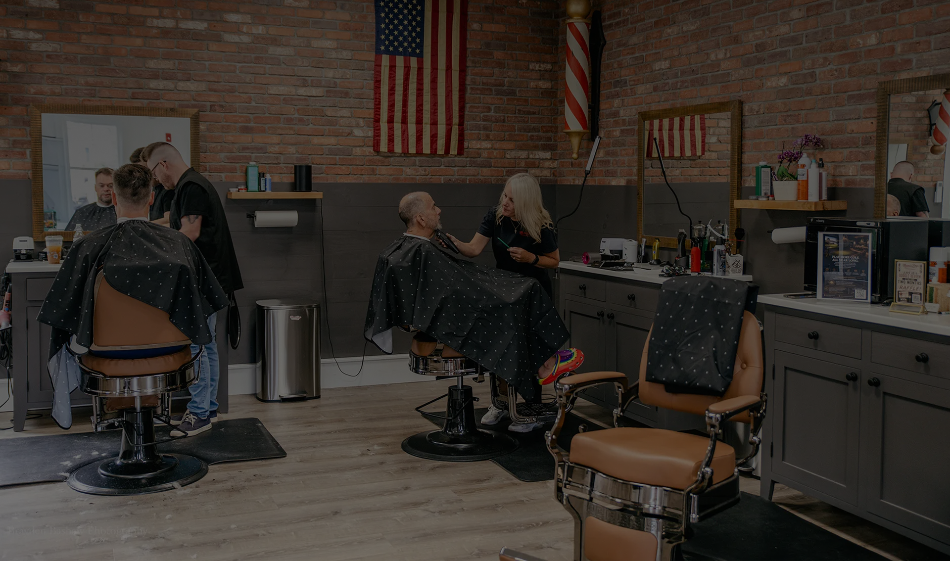 Modern interior of Mama's Boys Barbershop with barbers serving clients.