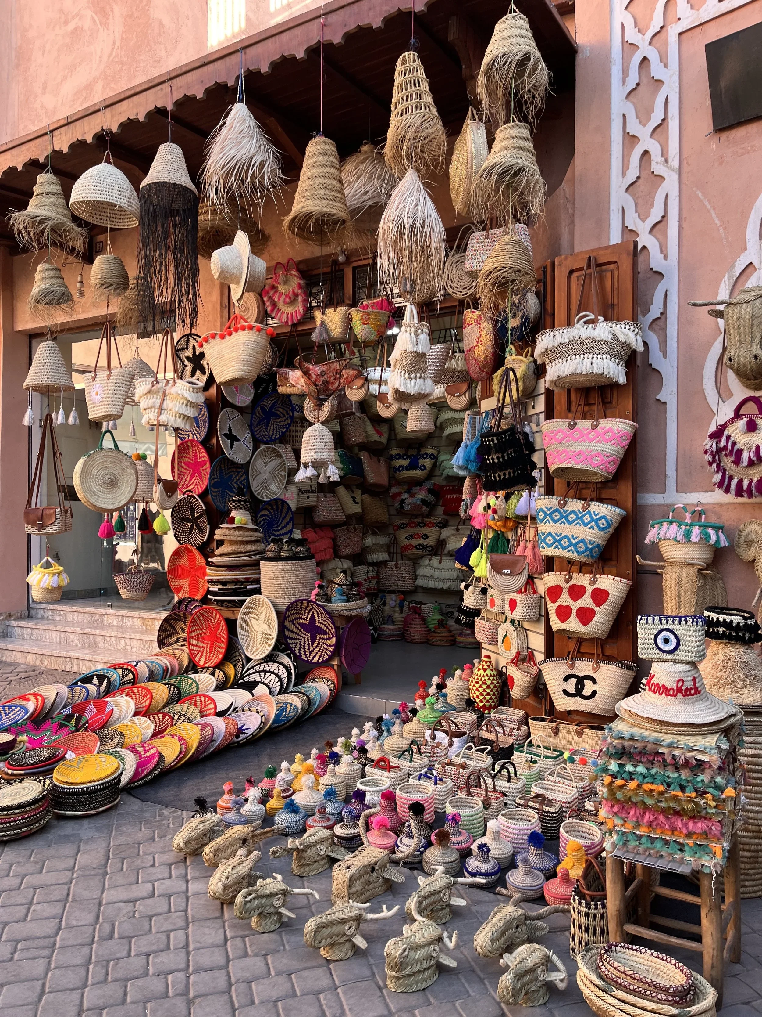 Stall in a Moroccan souk in Marrakesh filled with hand-woven colourful baskets and wall hangings.