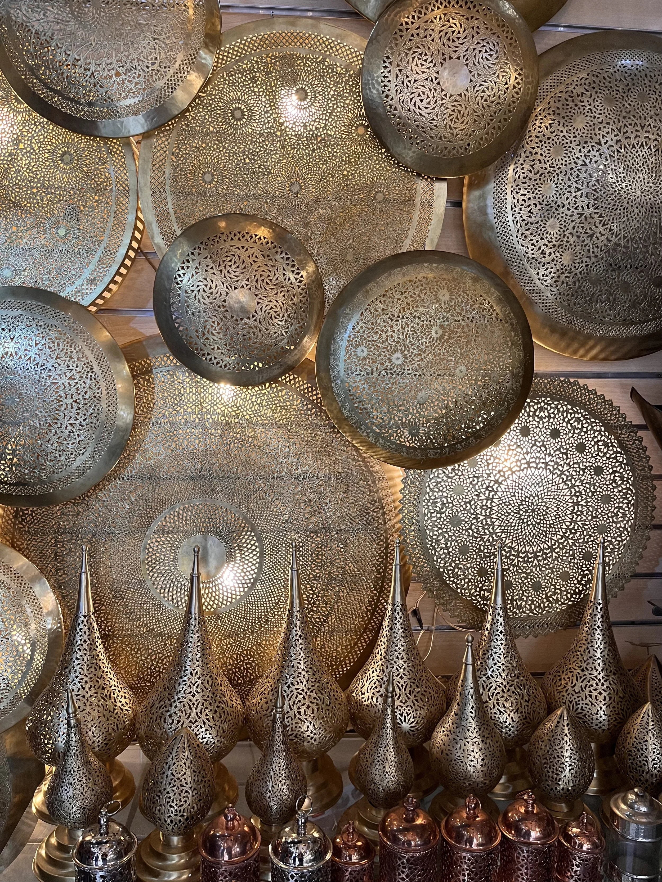 Stall in a Moroccan souk in Marrakesh filled with intricately carved golden lanterns.