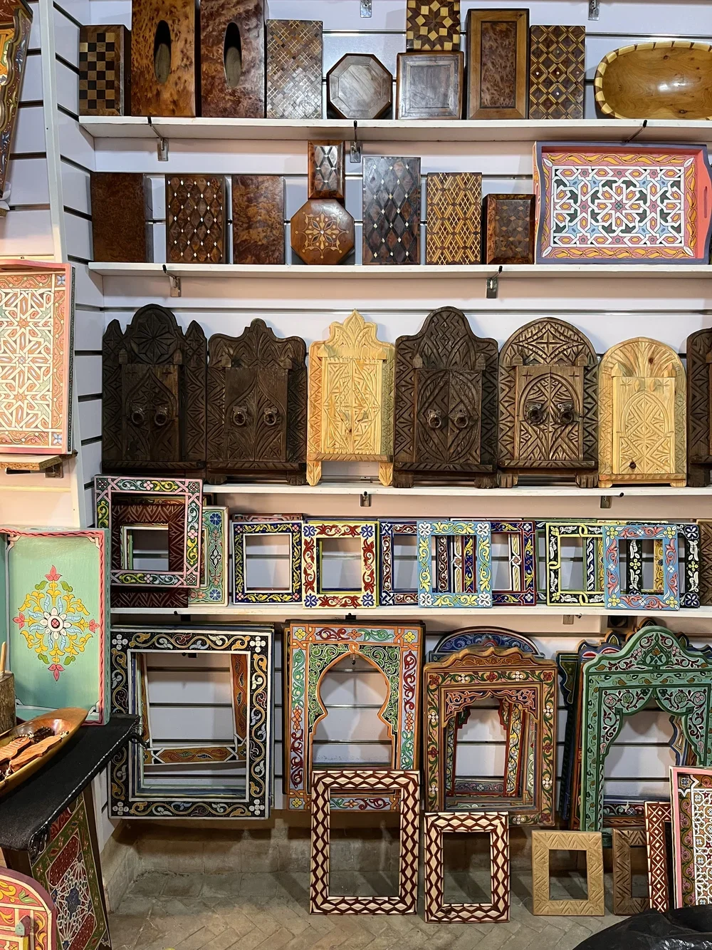 Hand-carved and hand-painted frames and wall hangings in a Moroccan souk.