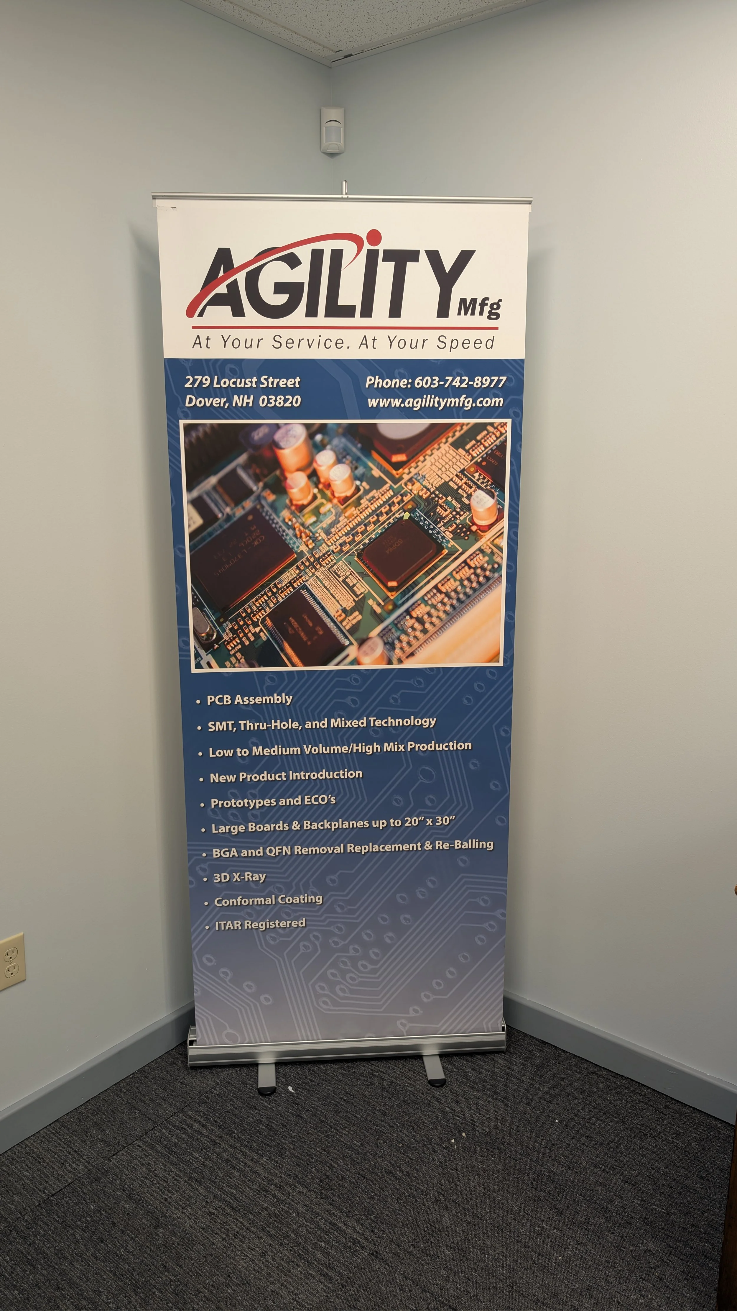 A vertical banner for Agility Mfg, a manufacturing company, featuring an image of a circuit board and a list of services offered, including PCB assembly, SMT, prototype production, and more. The banner displays the company's contact information and slogan.