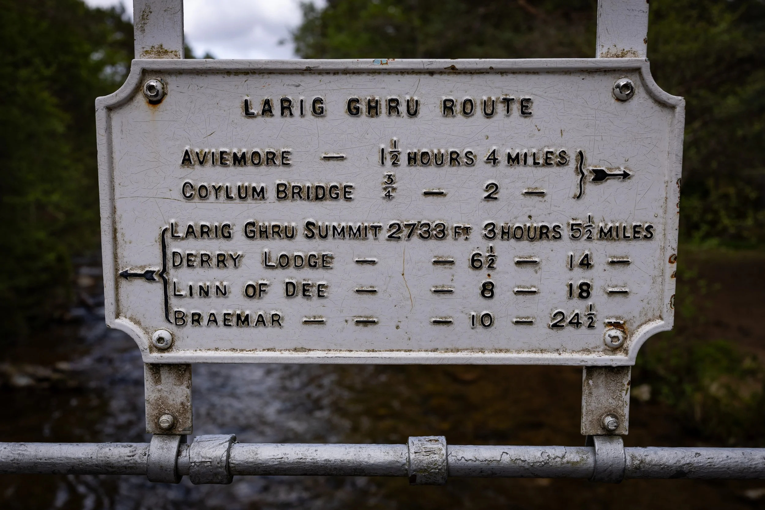 An old Lairig Ghru route sign showing distances to Aviemore, Coylumbridge, Braemar and the wider mountain route.