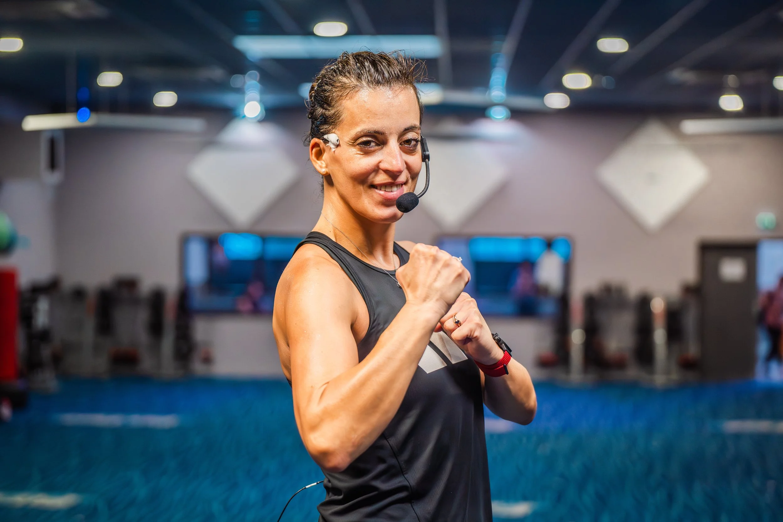 Femme faisant de l'exercice avec un micro casque dans une salle de sport.