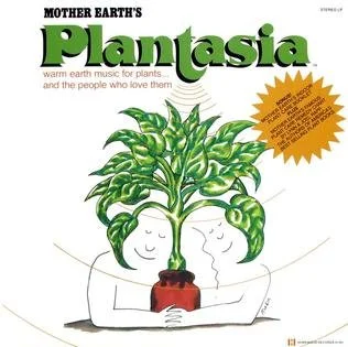 A record album titled "Mother Earth's Planasia" featuring an illustrated plant with a smiling face, surrounded by an orange burst shape with additional text.