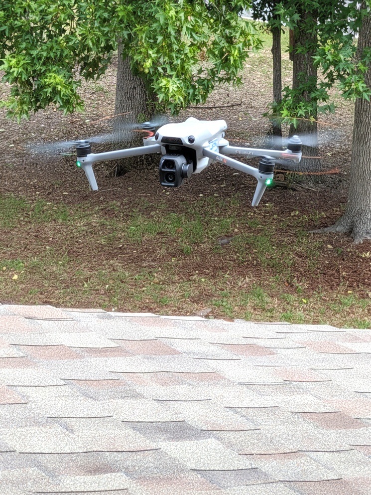 Drone hovering over roof for aerial roof inspection.