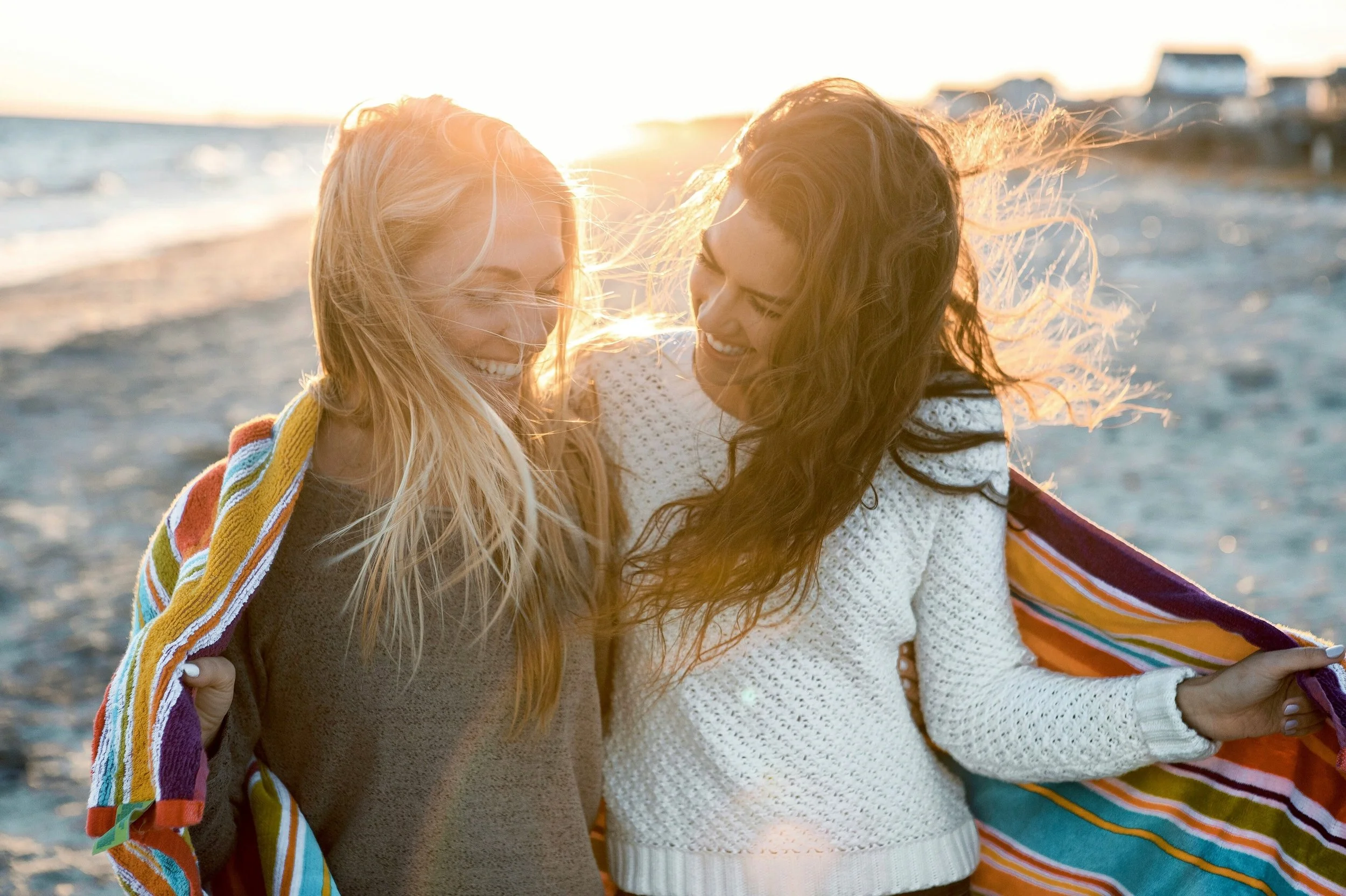 Two women enjoying time together on the beach, representing meaningful relationships and connection.