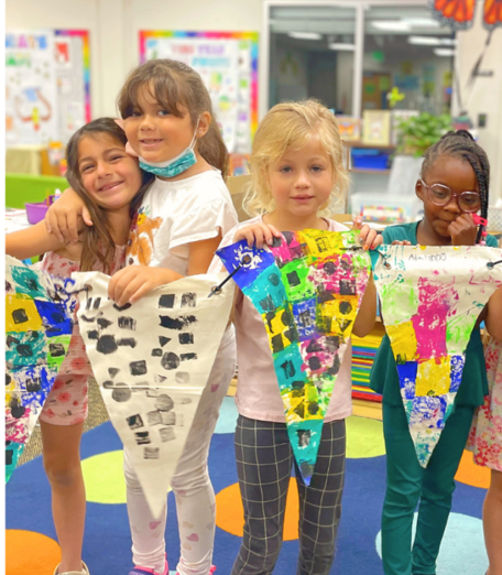 4 girls holding painted triangle banners