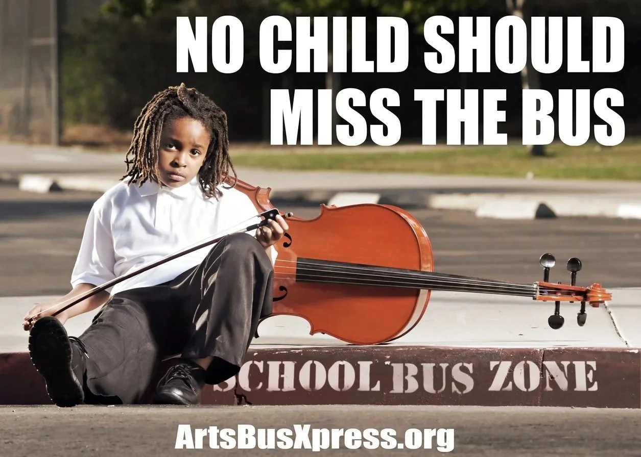 young boy holding bow sitting on curb that says School Bus Zone.
