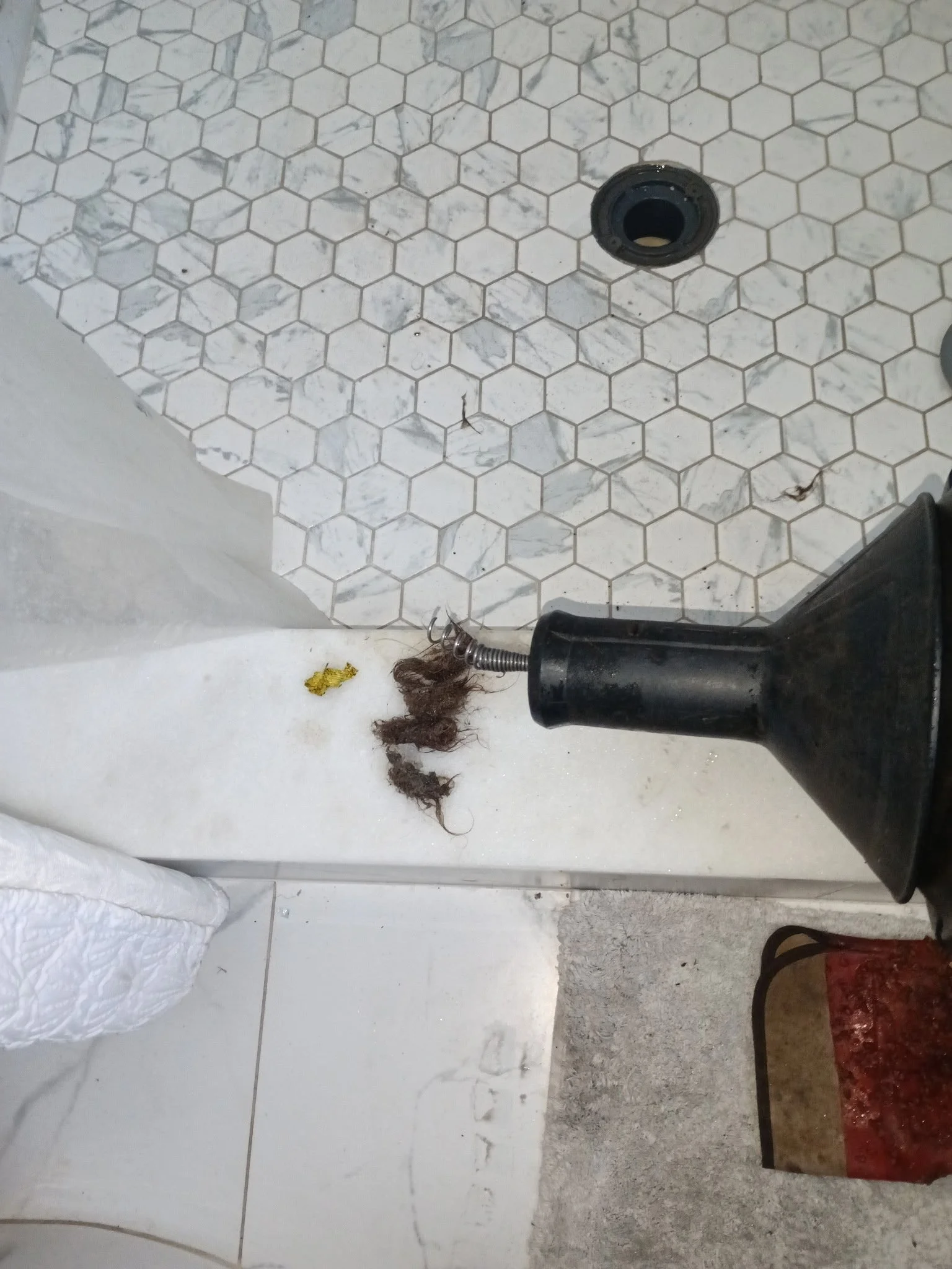 Remove hair debris from bathtub drain with a hand drain machine tool.