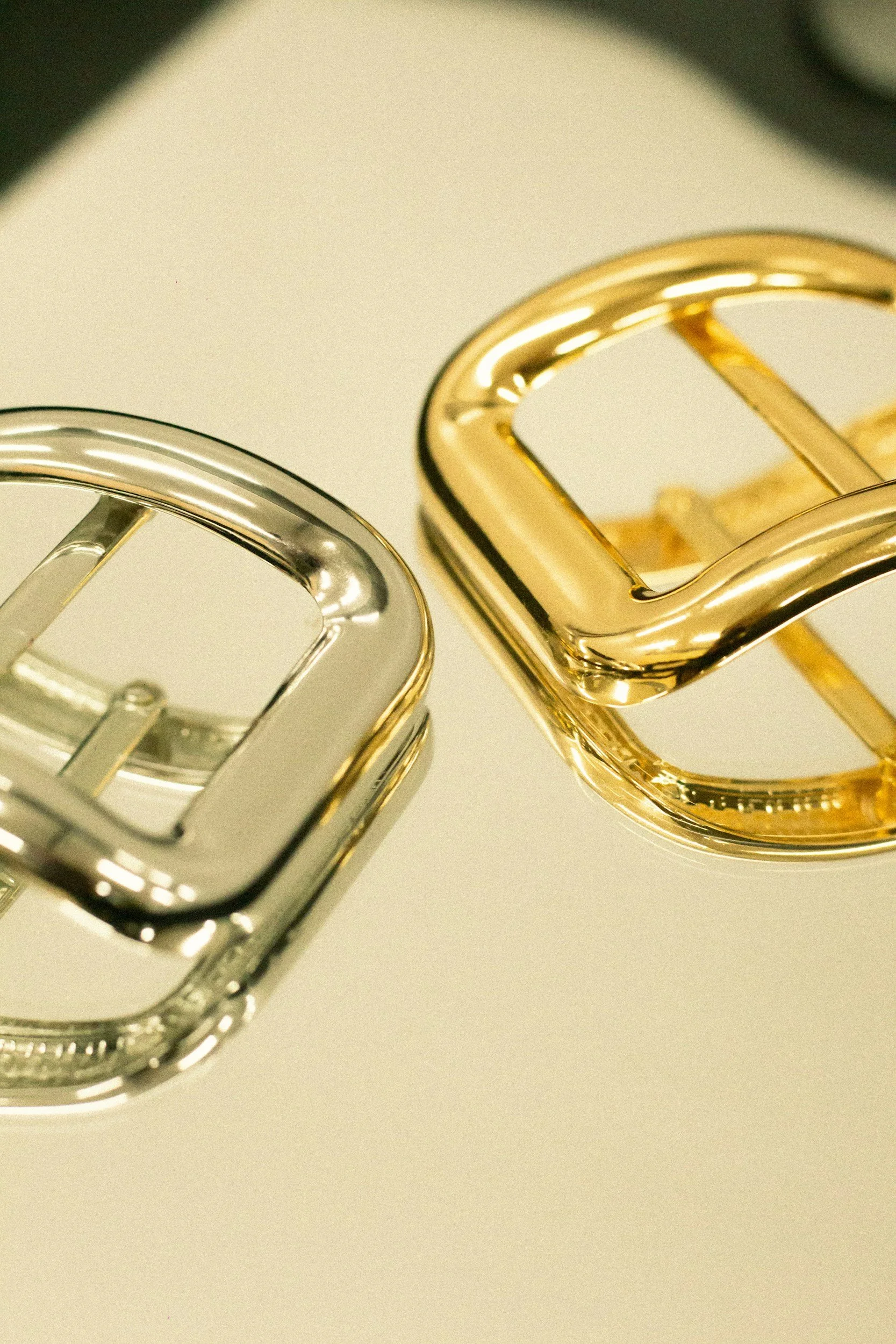 Close-up of metallic metallic objects, one silver and one gold, with a blurred background.