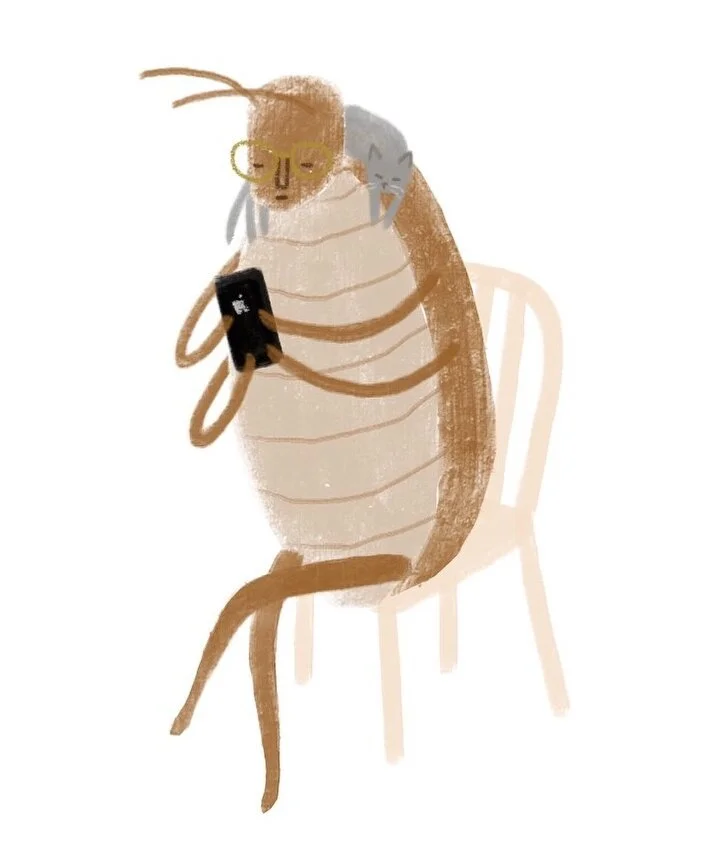 A person with glasses and a brown striped dress sitting on a chair, holding a smartphone, with a gray cat hugging their head.
