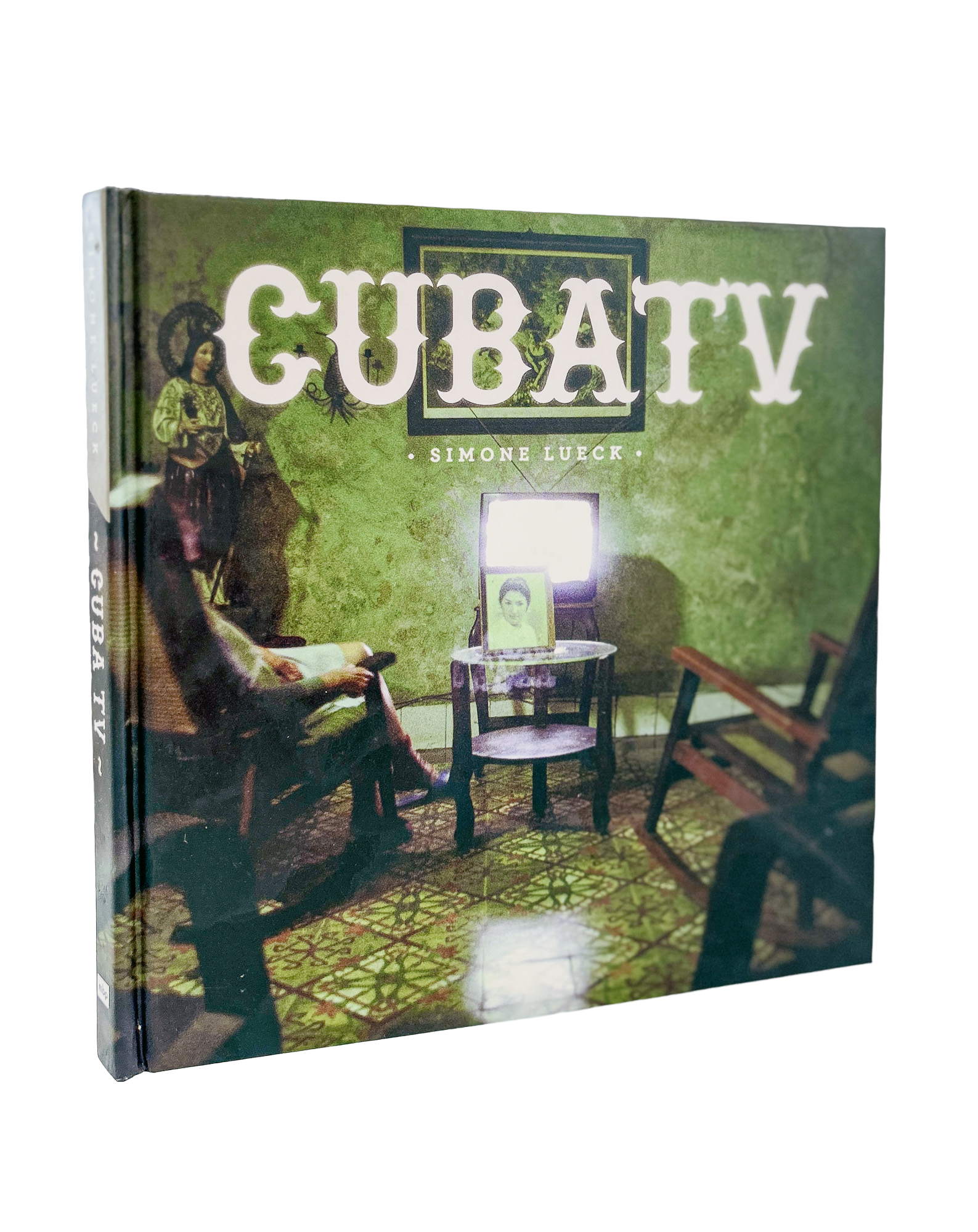 Book titled 'The Gubat' by Simone Luck with a cover illustration of a vintage scene featuring a woman in historical clothing sitting in a room with chairs and a patterned green rug.