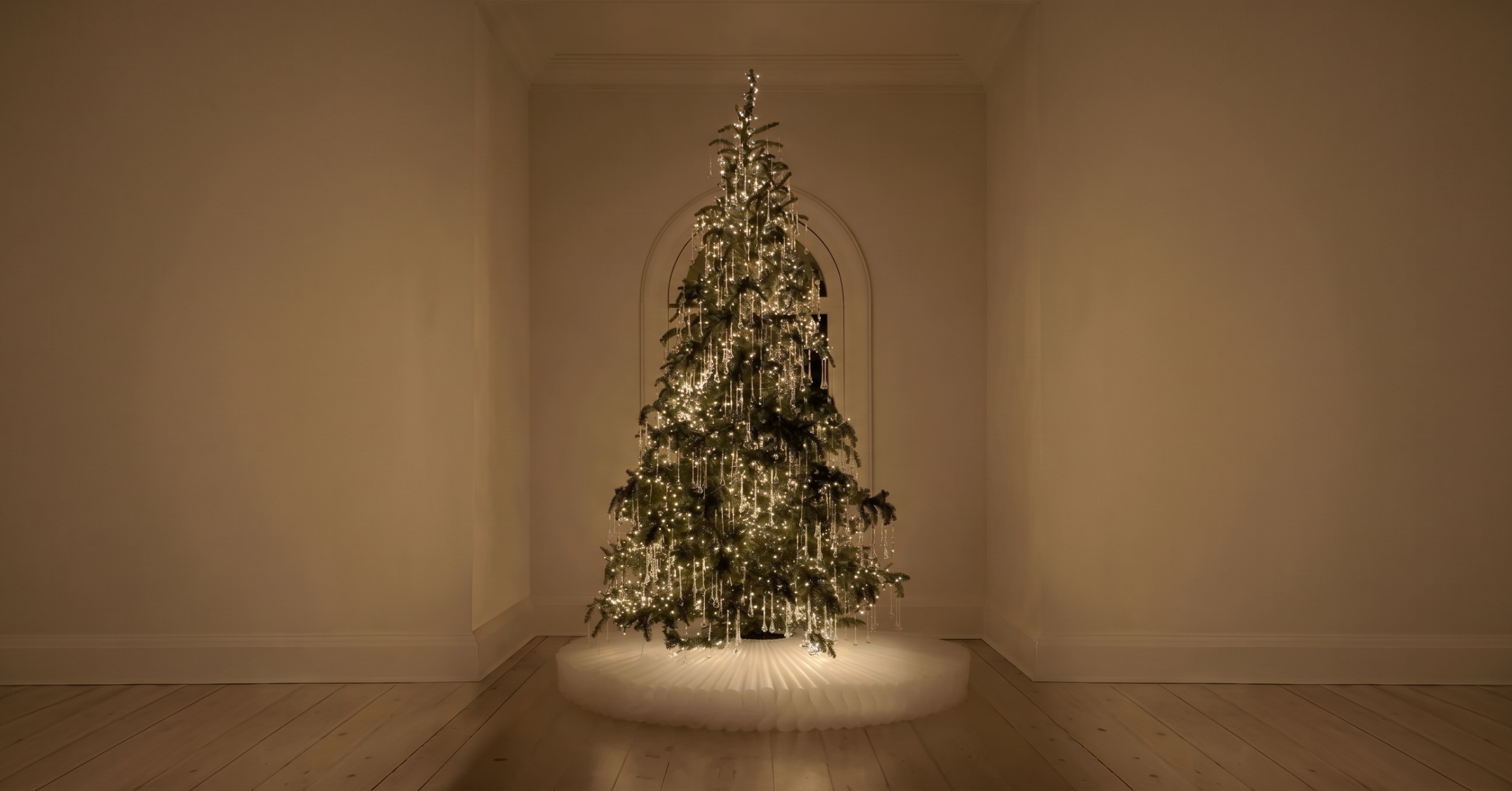 Softly lit holiday tree with cascading crystal strands in a warm, minimal room — luxury holiday design by Jacqueline Row, Atlanta
