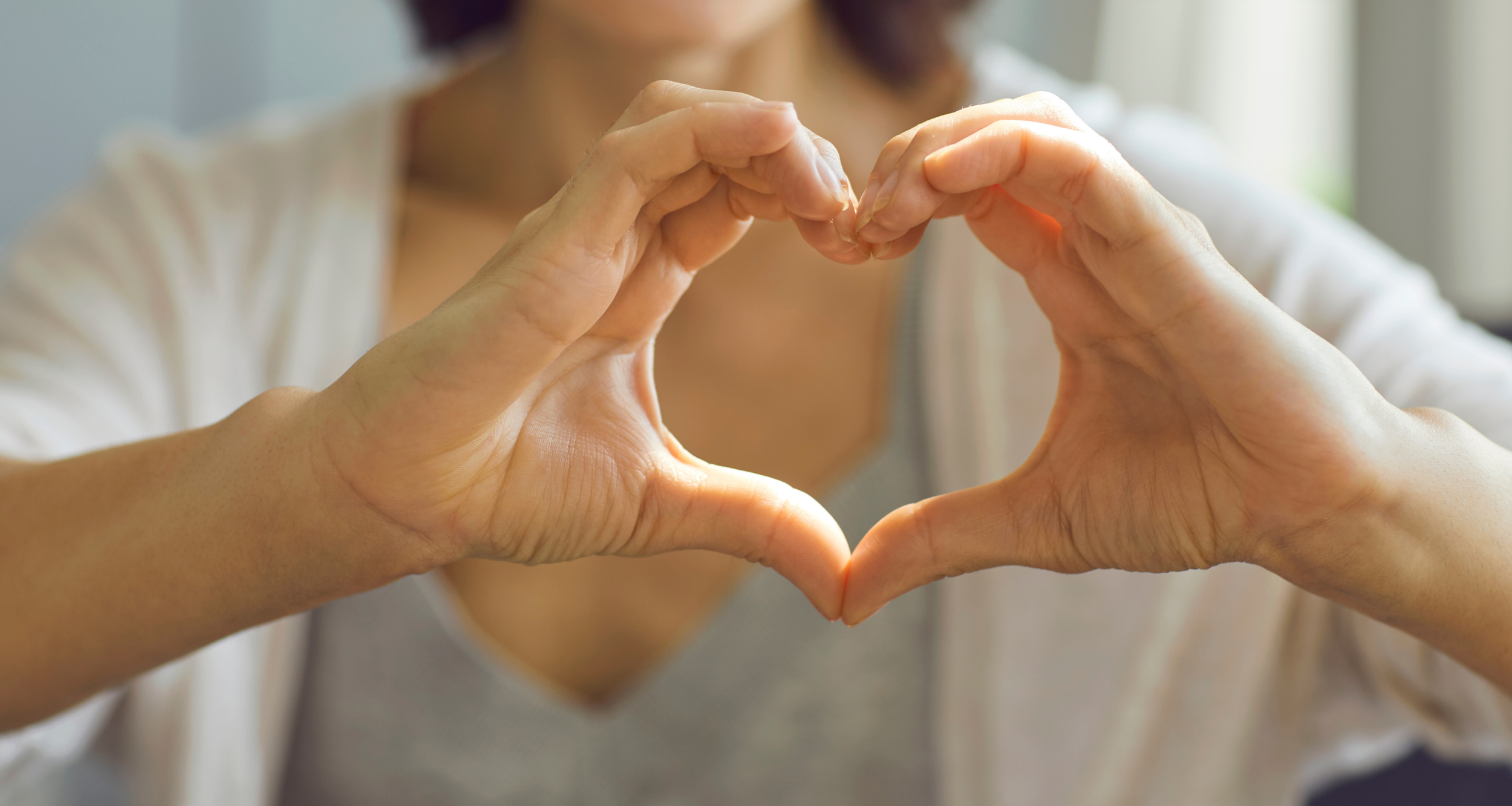 Person forming a heart shape with their hands.