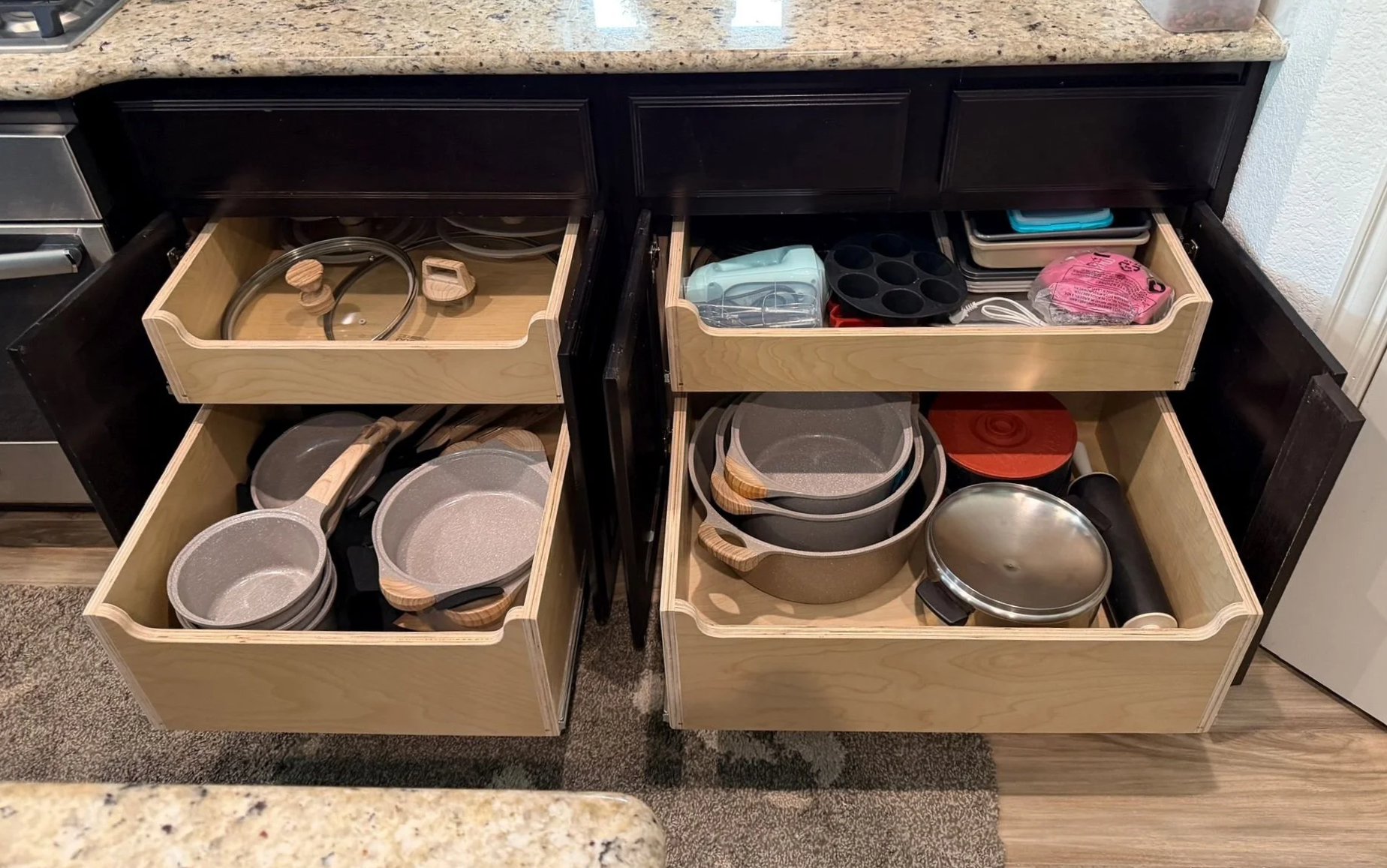 Kitchen pull out drawers extended with pots and pans.