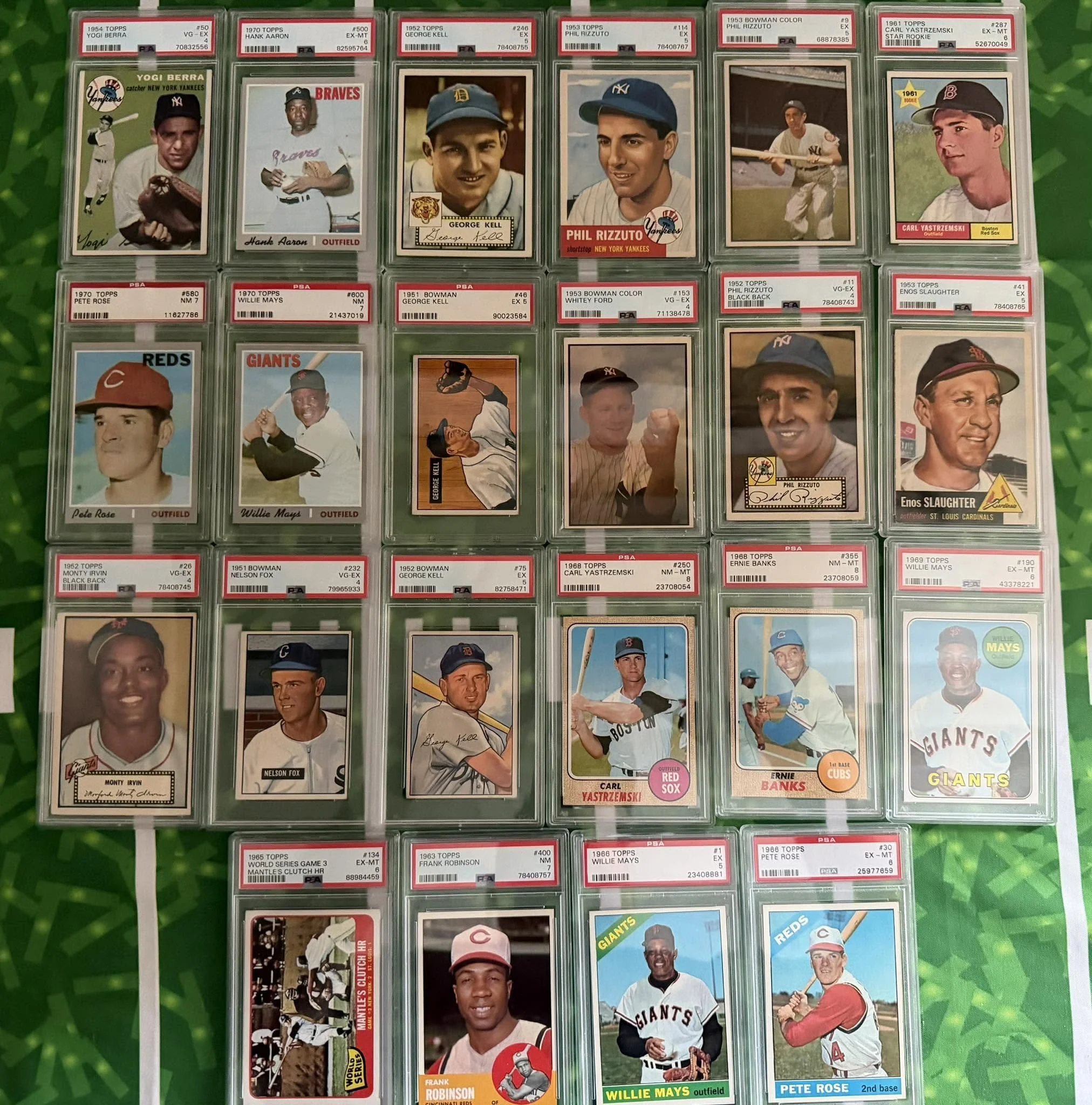 A collection of vintage baseball trading cards featuring players from various teams, each card encapsulated in protective plastic cases with labels indicating player names, team affiliations, and grading details.