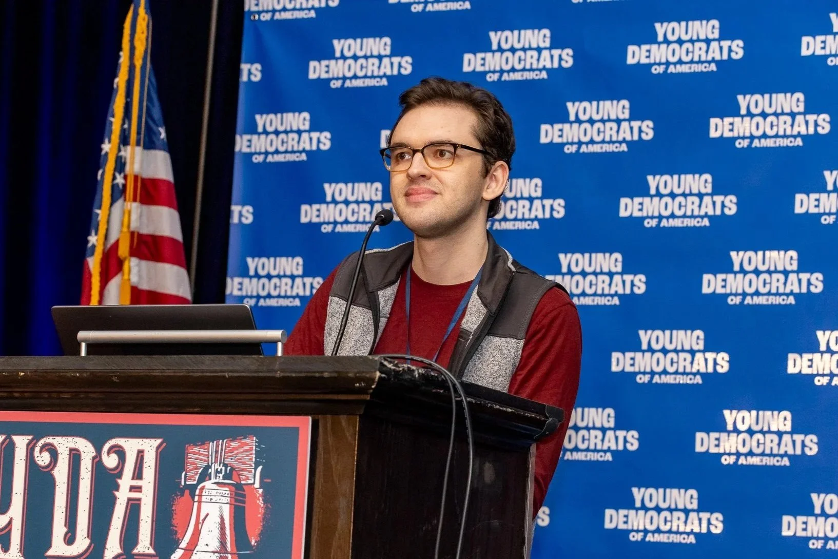 NYSYD logo with a blue background, white text that says "New York State Young Democrats," and a small illustration of the Statue of Liberty torch