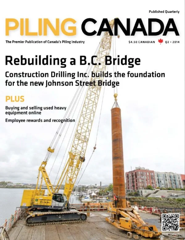 Cover of Piling Canada magazine featuring construction of a bridge in B.C., Canada, with a large yellow crane lifting a cylindrical steel pile into place.