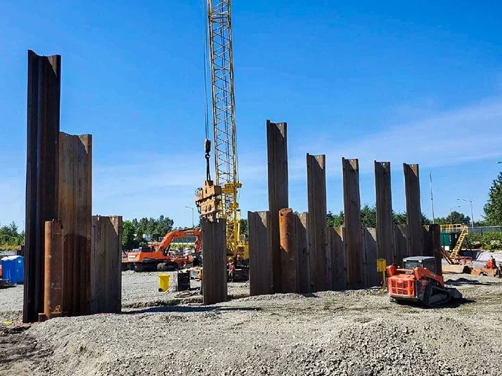 Construction site with steel beams and a crane, preparing for building foundation