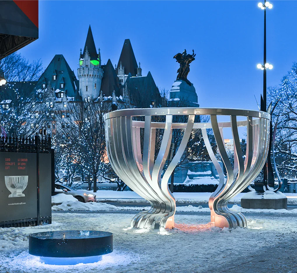 Sculpture of a large cup form shown in winter at night