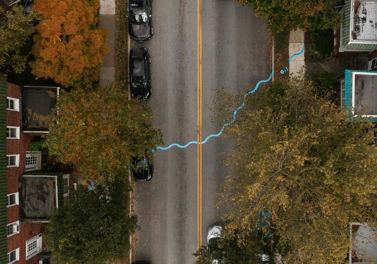 Aerial view of a wavy blue line painted on a two-lane road