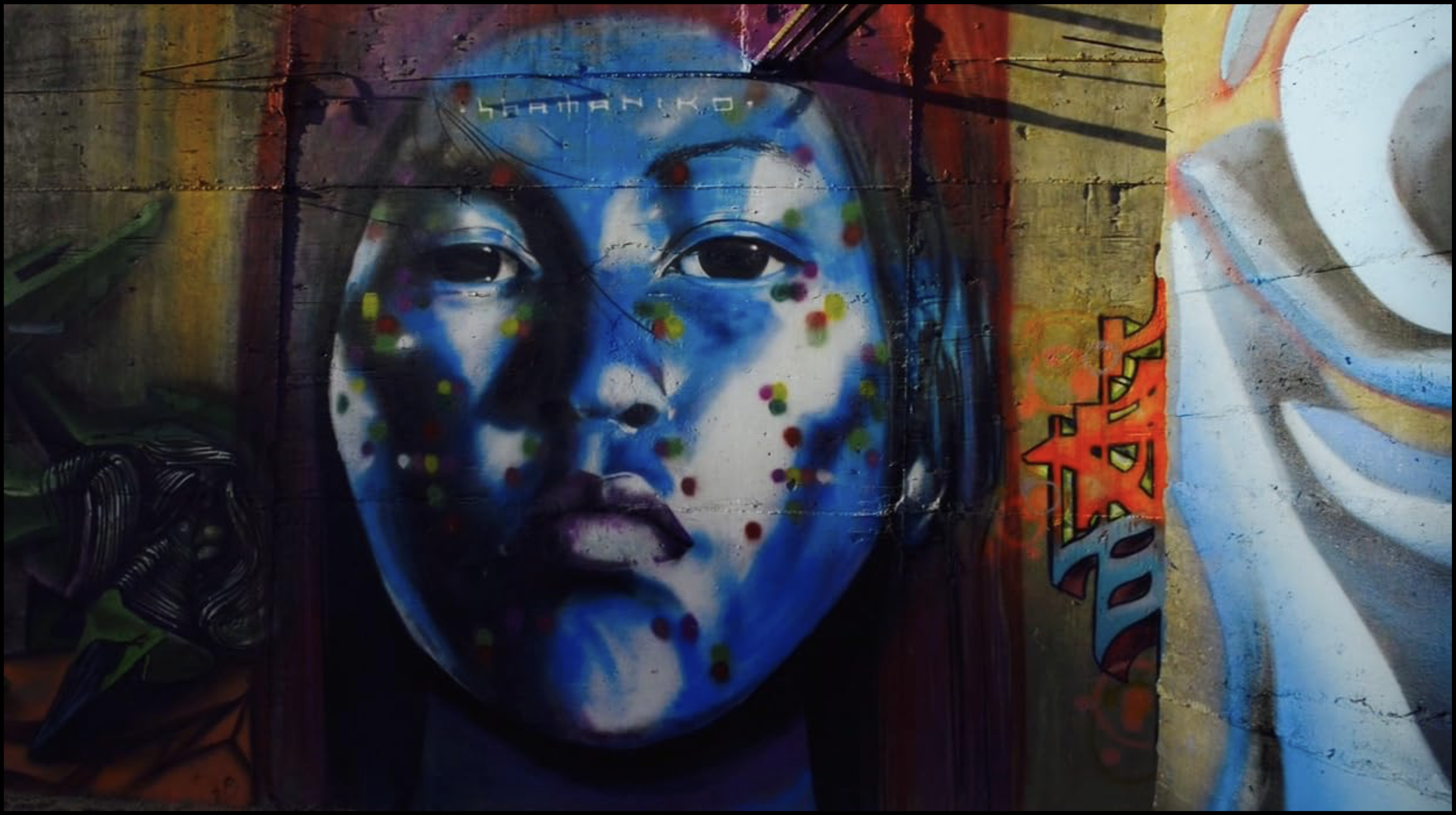 Close up view of mural showing a blue face